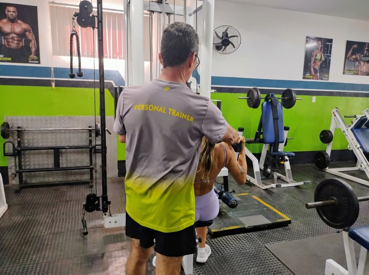 Personal trainer acompanhando aluno na Academia Bom Físico