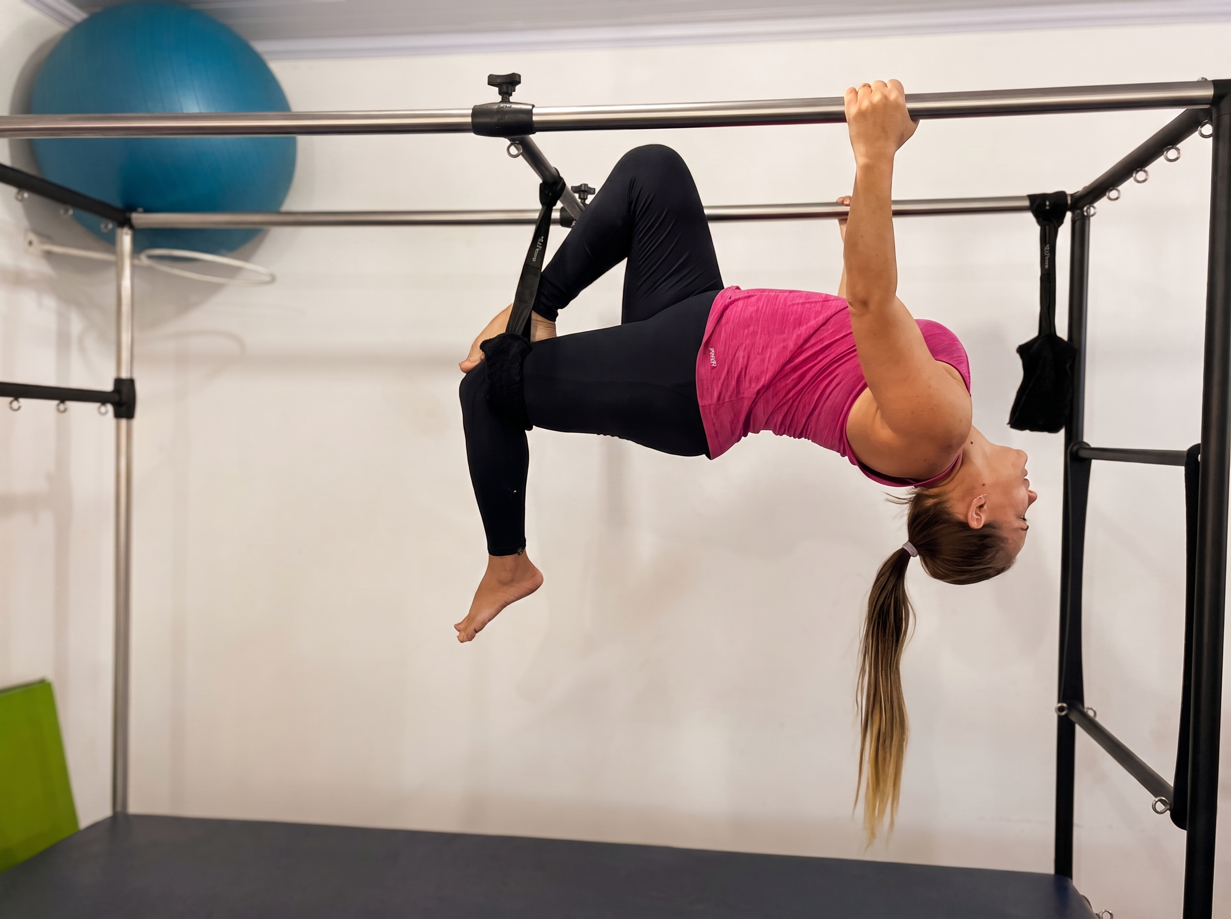 Instrutora acompanhando aluna em aparelho de Pilates na Academia Bom Físico